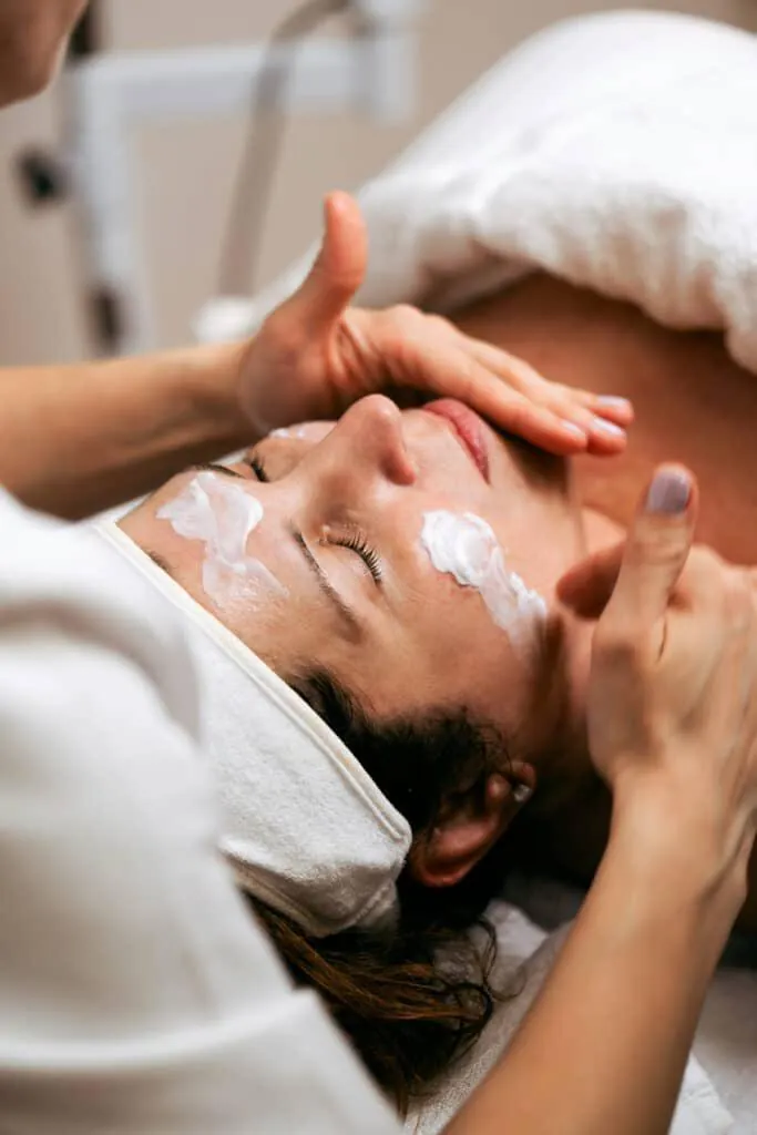 Application d’un soin du visage à mains nues, en cabine